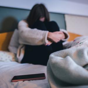 Sad teen youth sitting on the bed