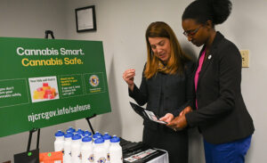 Dr. Diane Calello, medical executive director for the New Jersey Poison Control Center (left), and Dianna Houenou, chair of the New Jersey Cannabis Regulatory Commission, examine cannabis safe storage pouches at the launch of the CRC’s statewide cannabis safety campaign on Oct. 11, 2023. - CRC