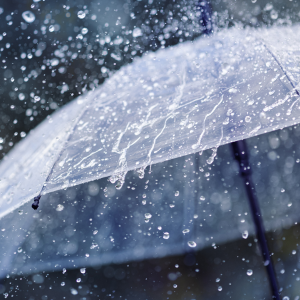 Downpour of heavy rain on top of an opened umbrella. 