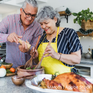 An older couple in the kitchen preparing food for their Thanksgiving dinner.