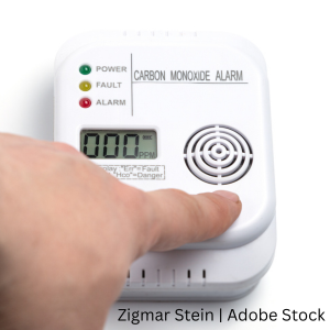 A person testing a carbon monoxide detector.