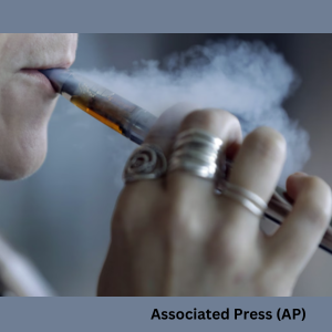 Close‑up of a young child inhaling from an electronic cigarette, with visible vapor coming from the device.