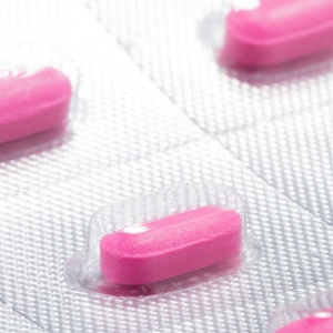 Close-up of pink allergy pills in a blister pack.